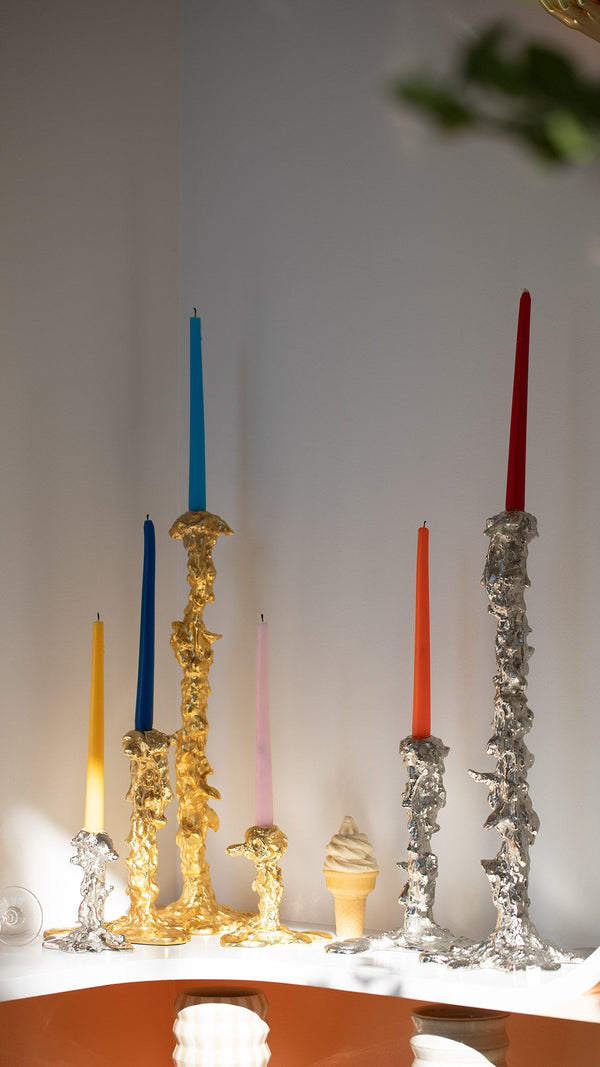 Polspotten candle holders on table.