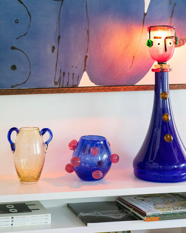 Yellow and blue vases on white book shelf.