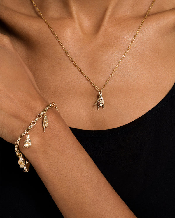 Model wearing a Sign Language Charm as a pendant on a chain and a charm bracelet with multiple Sign Language Charms