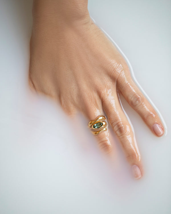 Photo of hand in milky water wearing the Equalize Ring stacked with the Fluctuating Bands.