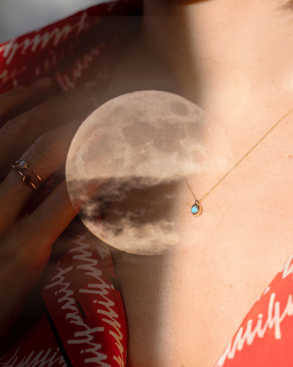 Editorial image of model's neck wearing the Birthstone level Necklace with a full moon super imposed over it.