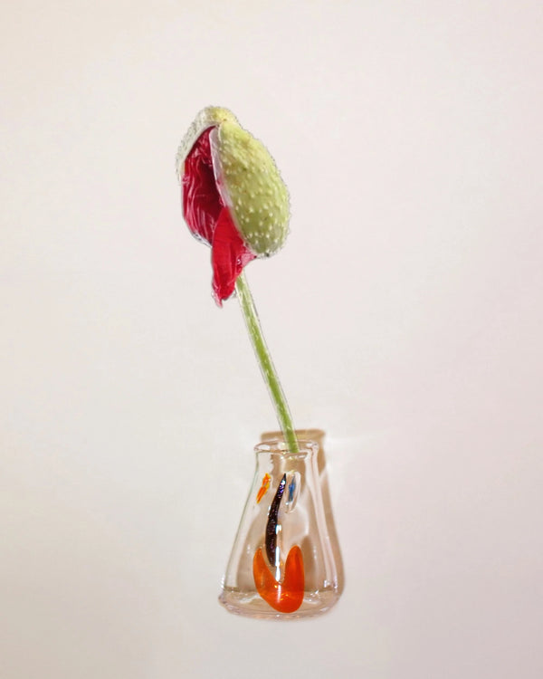 Editorial image of a Facevessel Bud Vase with an oversized poppy flower in a tan background