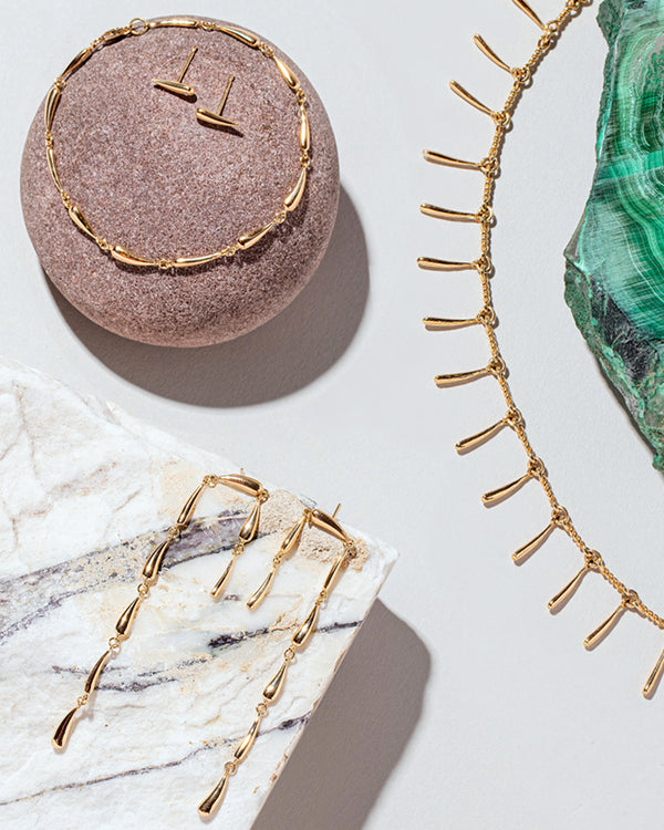 Photo of jewelry from the One & Others Collection laid on top of natural rocks and marble pieces