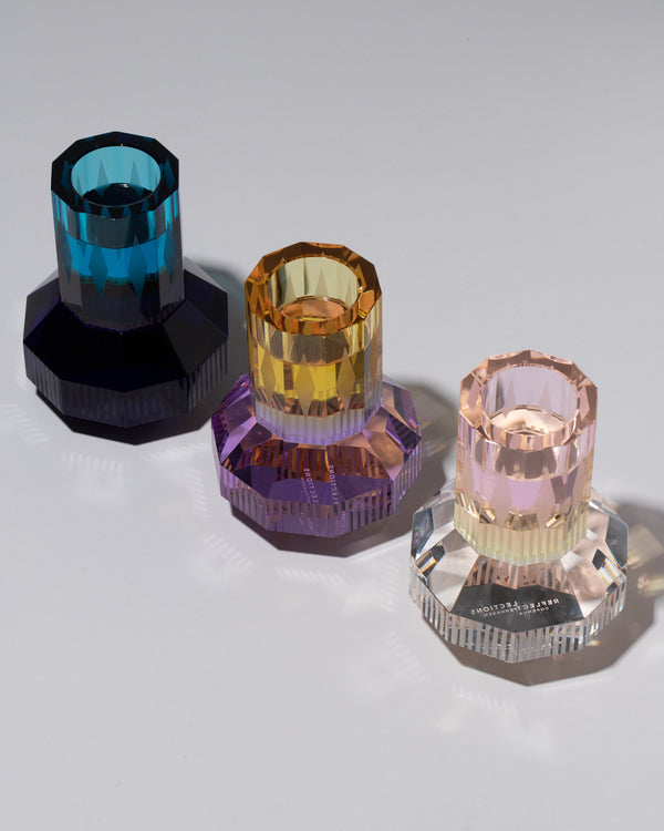 Reflections Copenhagen Collection glass light holders in various colors on a neutral-light background.