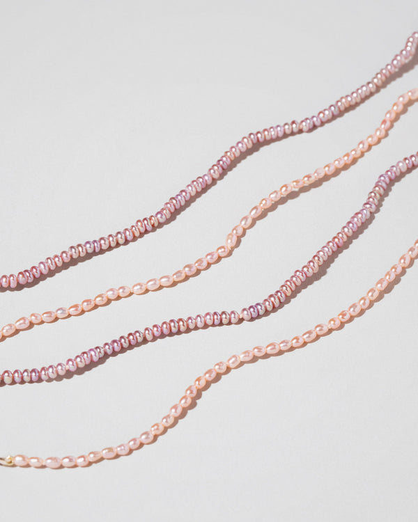 Closeup details of the Pink Lavender Seed Pearl Anklets and Pink Peony Oval Pearl Bracelets on light color background.