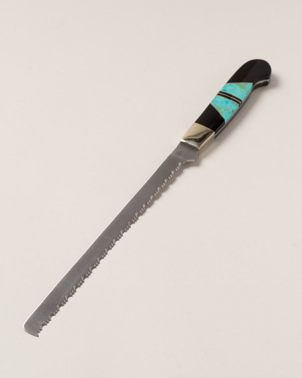 Santa Fe Stoneworks Collection bread knife with turquoise inlay on the handle, on a neutral-light background.