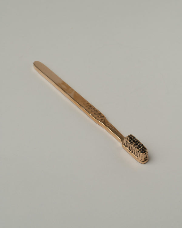Pearce Objects Bronze Toothpaste Tube on light color background.