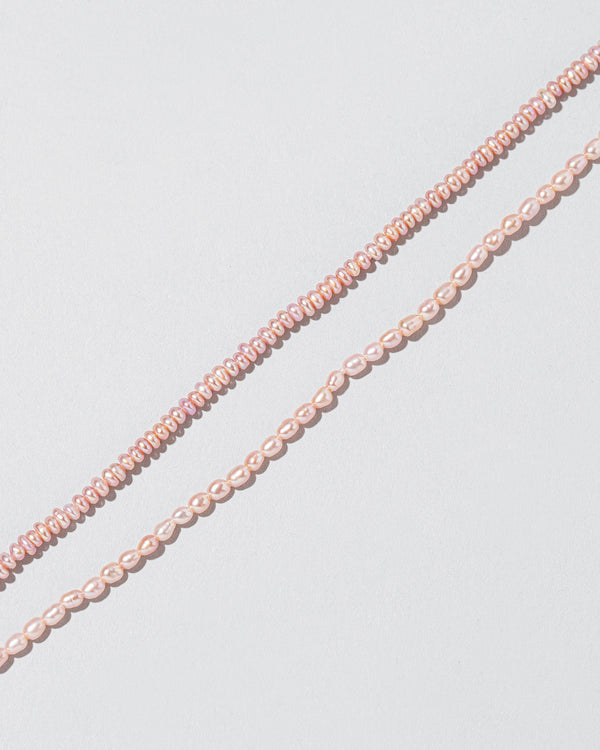 Closeup details of the Pink Peony Seed Pearl Anklet and Pink Peony Oval Pearl Bracelet on light color background.
