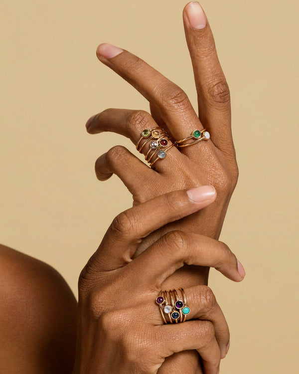 Photo of model's hands wearing Birthstone Rings in a off the birthstones.