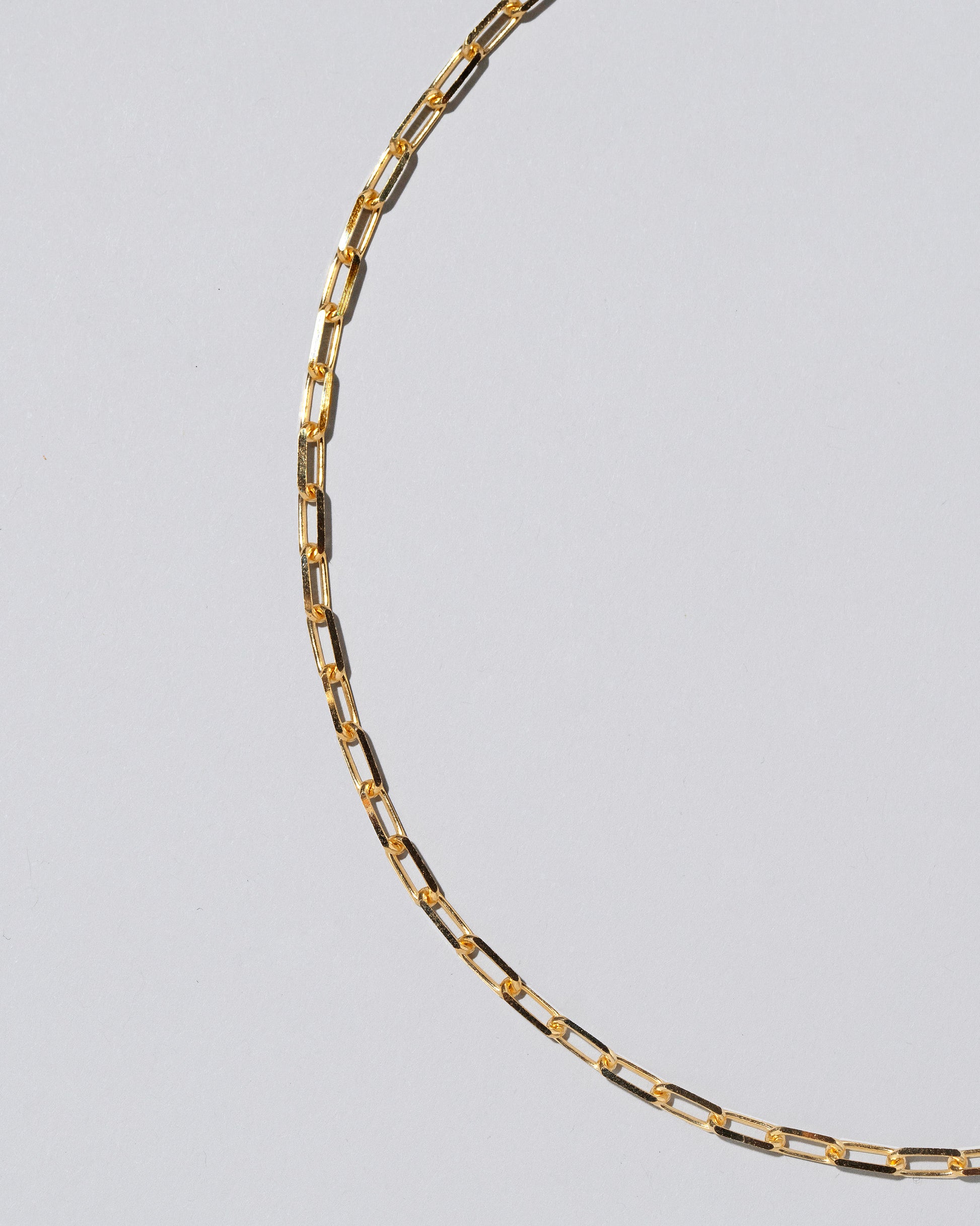 Closeup detail of the 3.5mm Beveled Oval Chain Necklace on light color background.