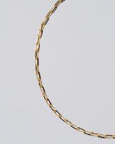 Closeup detail of the 3.5mm Beveled Oval Chain Necklace on light color background.