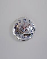 Silje Lindrup Red Hands Blue Glass Wall Clock on light color background.