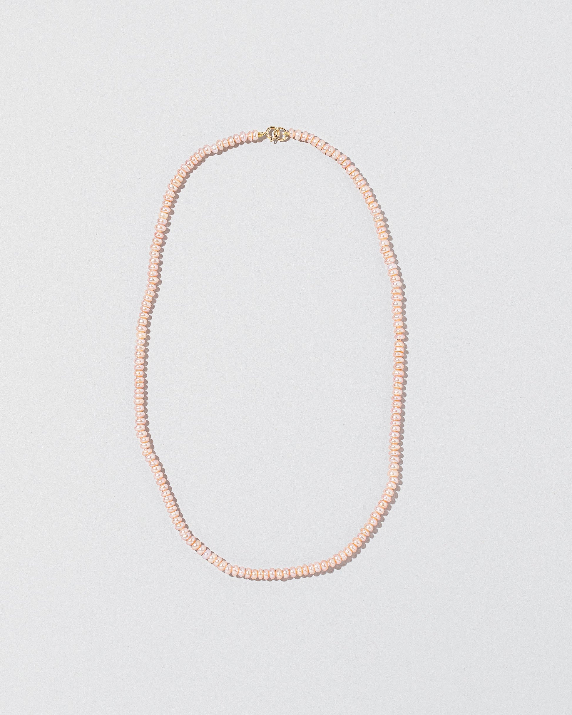 Pink Peony Pebble Seed Pearl Choker Necklace on light color background.