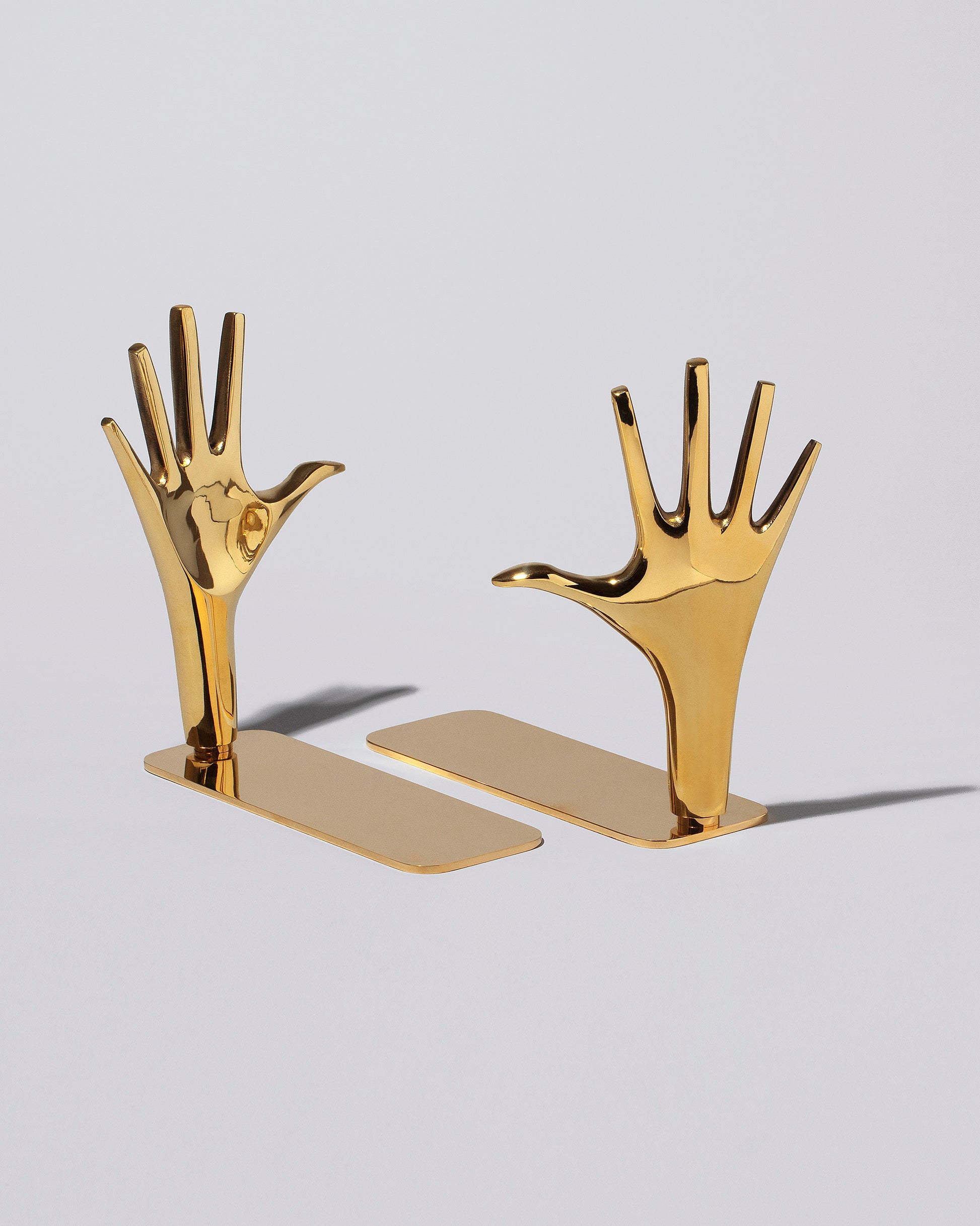 Carl Auböck Pair of Jazz Hands Brass Bookends Set on light color background.
