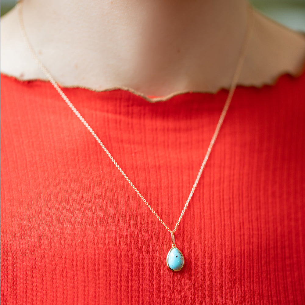product_details::State Shifter Turquoise Pendant paired with chain on model.
