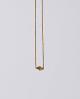 Gold Altered State Necklace on light color background.