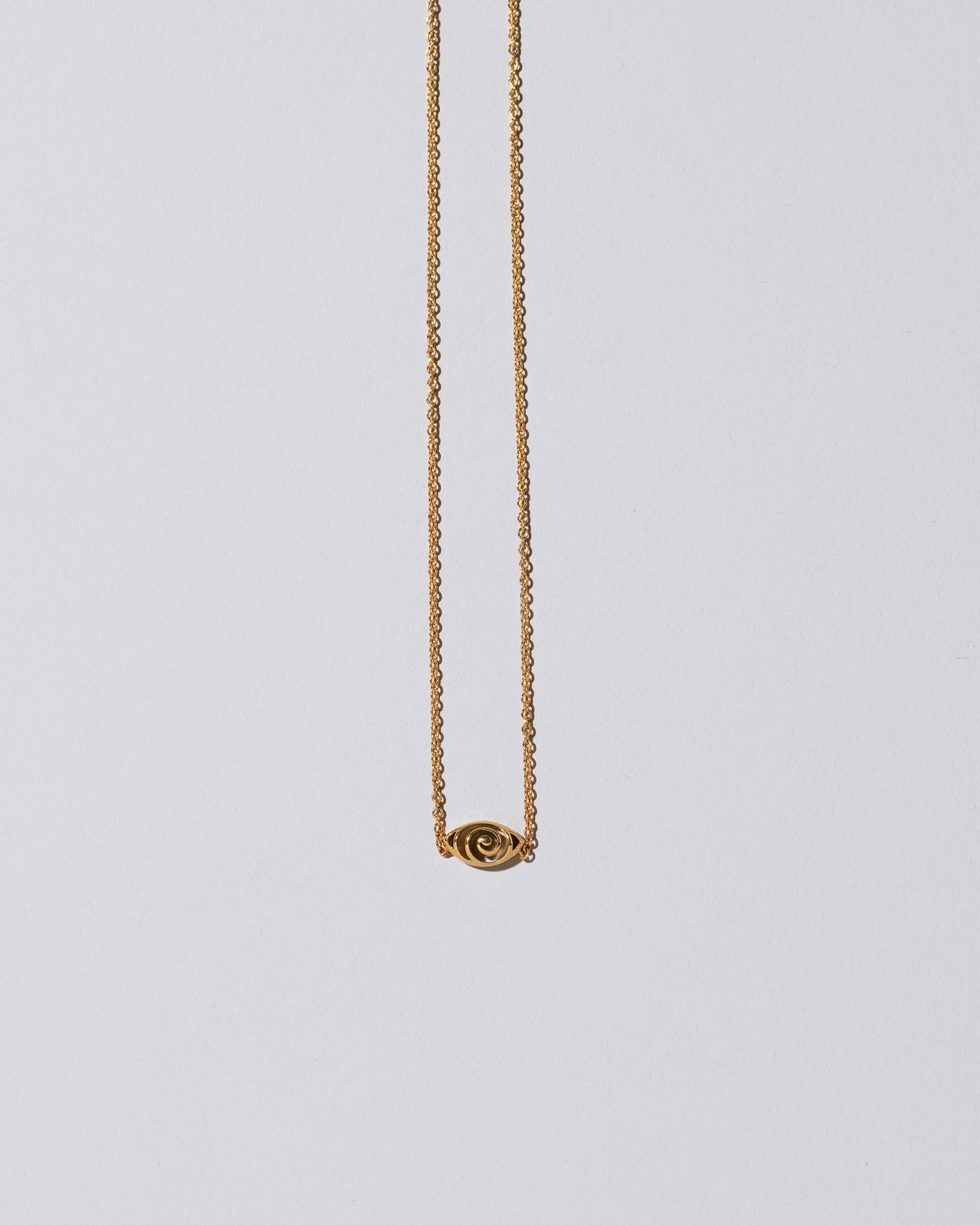 Gold Altered State Necklace on light color background.