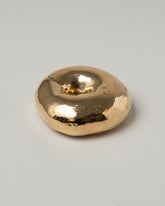 Closeup details of the Pearce Objects Cast Bronze Los Angeles Bagel on light color background.