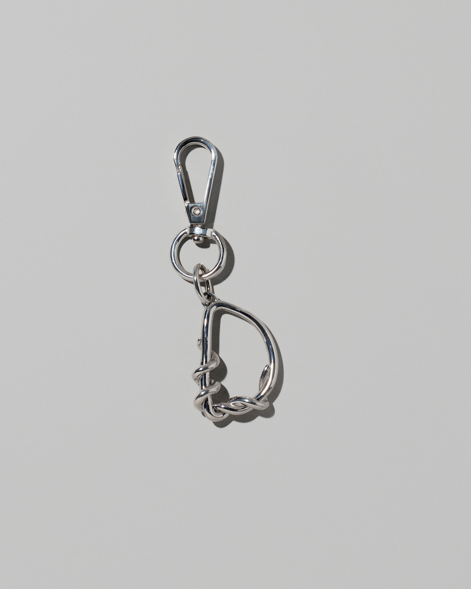 CRZM Sterling Silver Letter D Bag Charm with Clip on light color background.