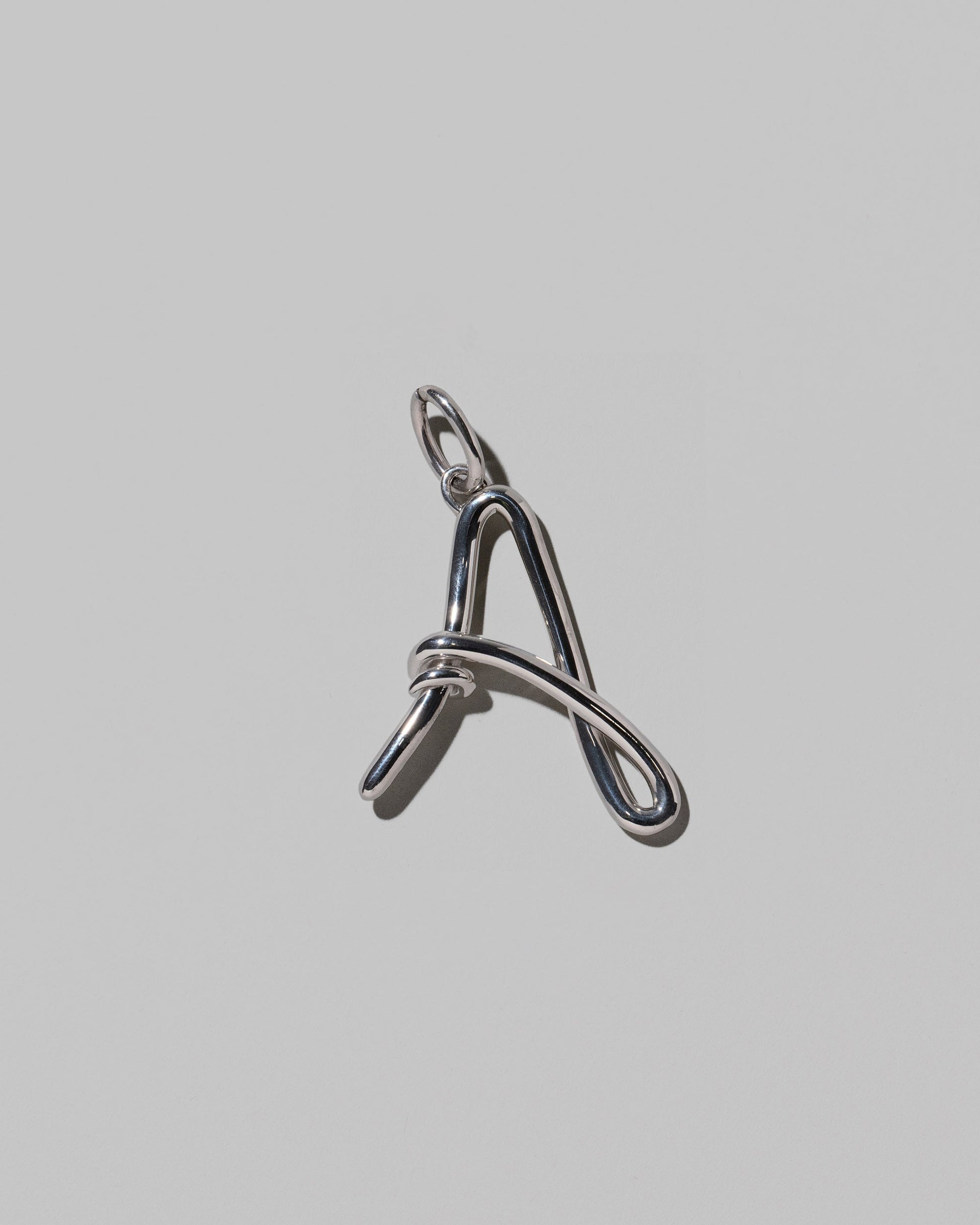 CRZM Sterling Silver Letter A Bag Charm on light color background.