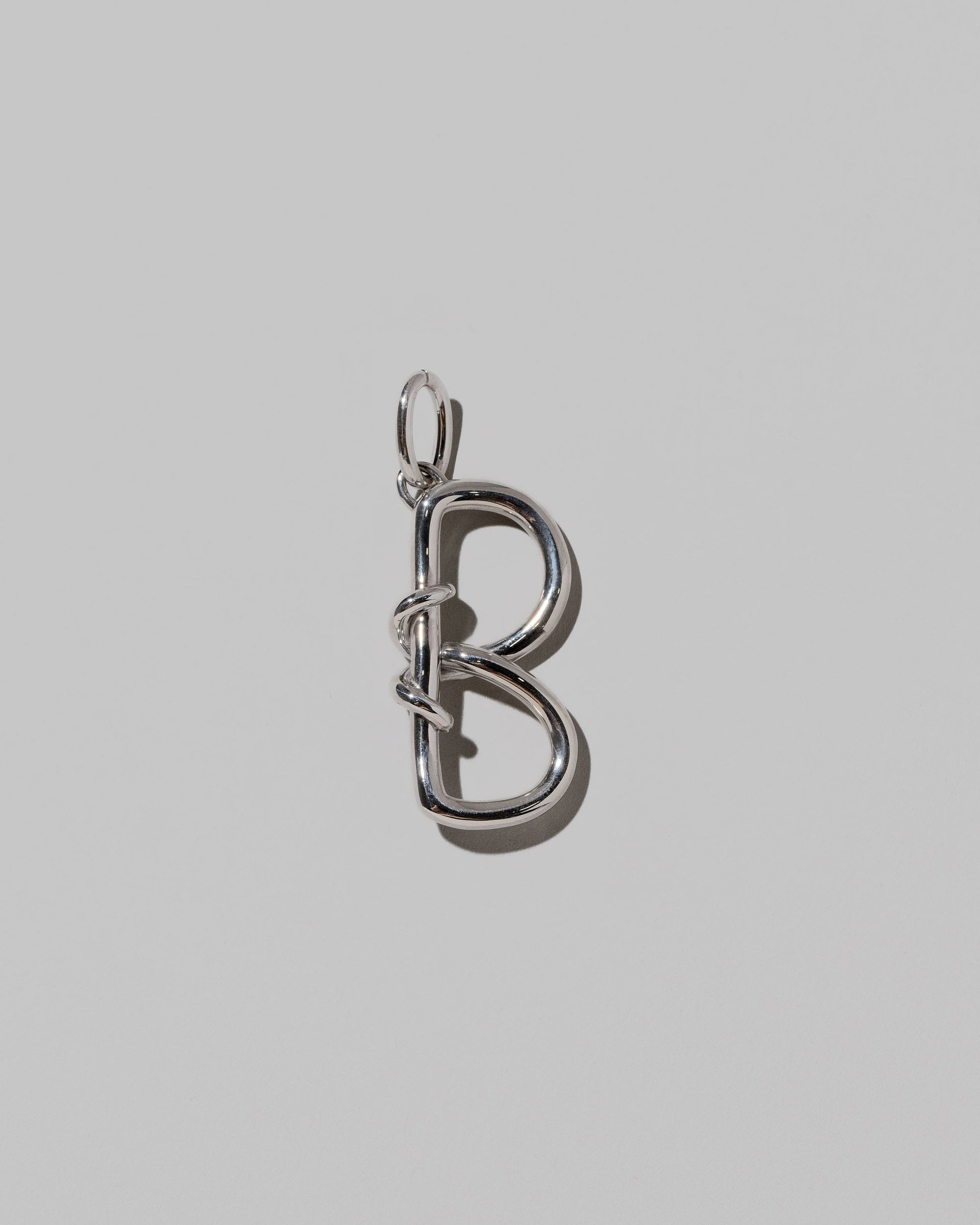 CRZM Sterling Silver Letter B Bag Charm on light color background.