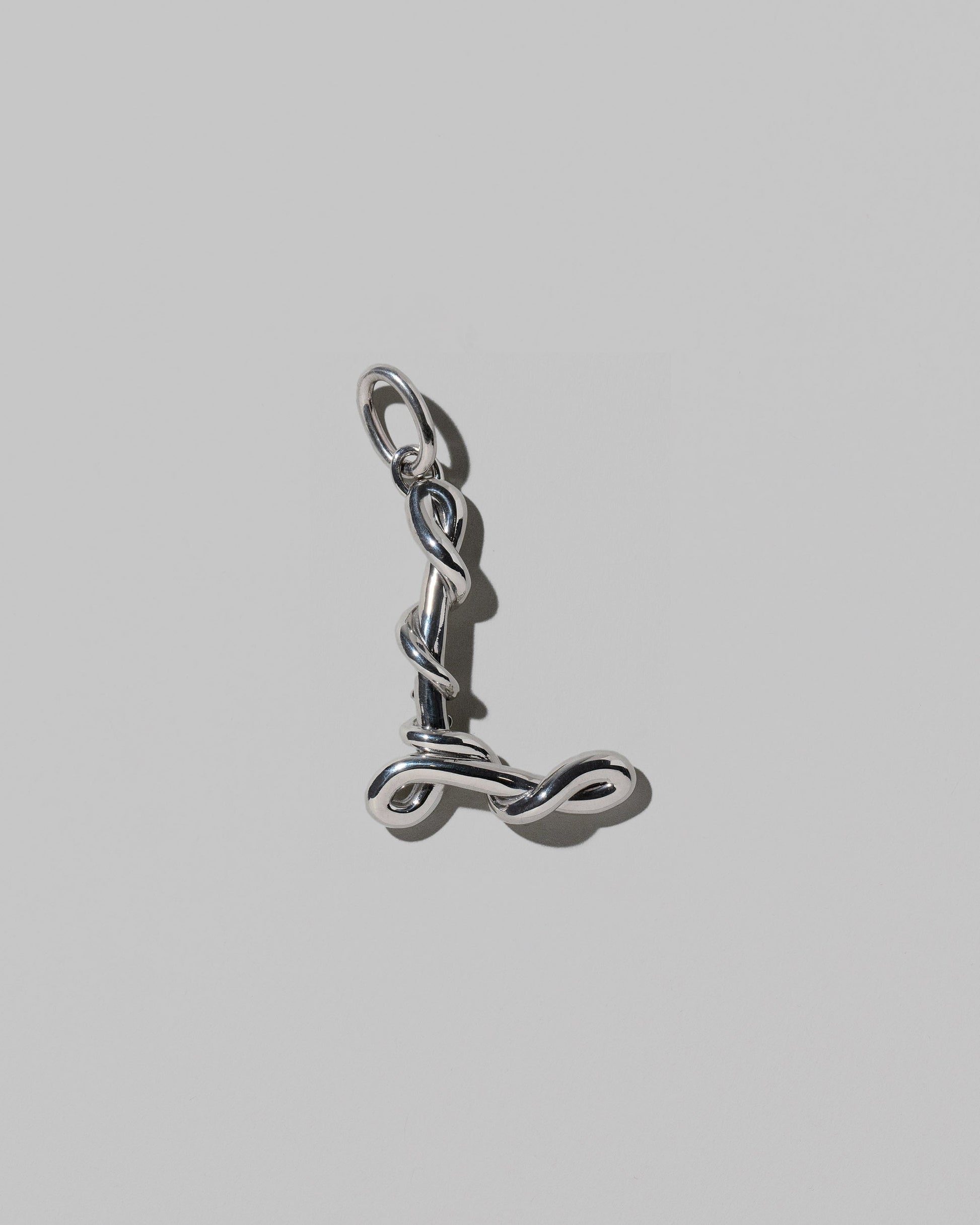 CRZM Sterling Silver Letter L Bag Charm on light color background.