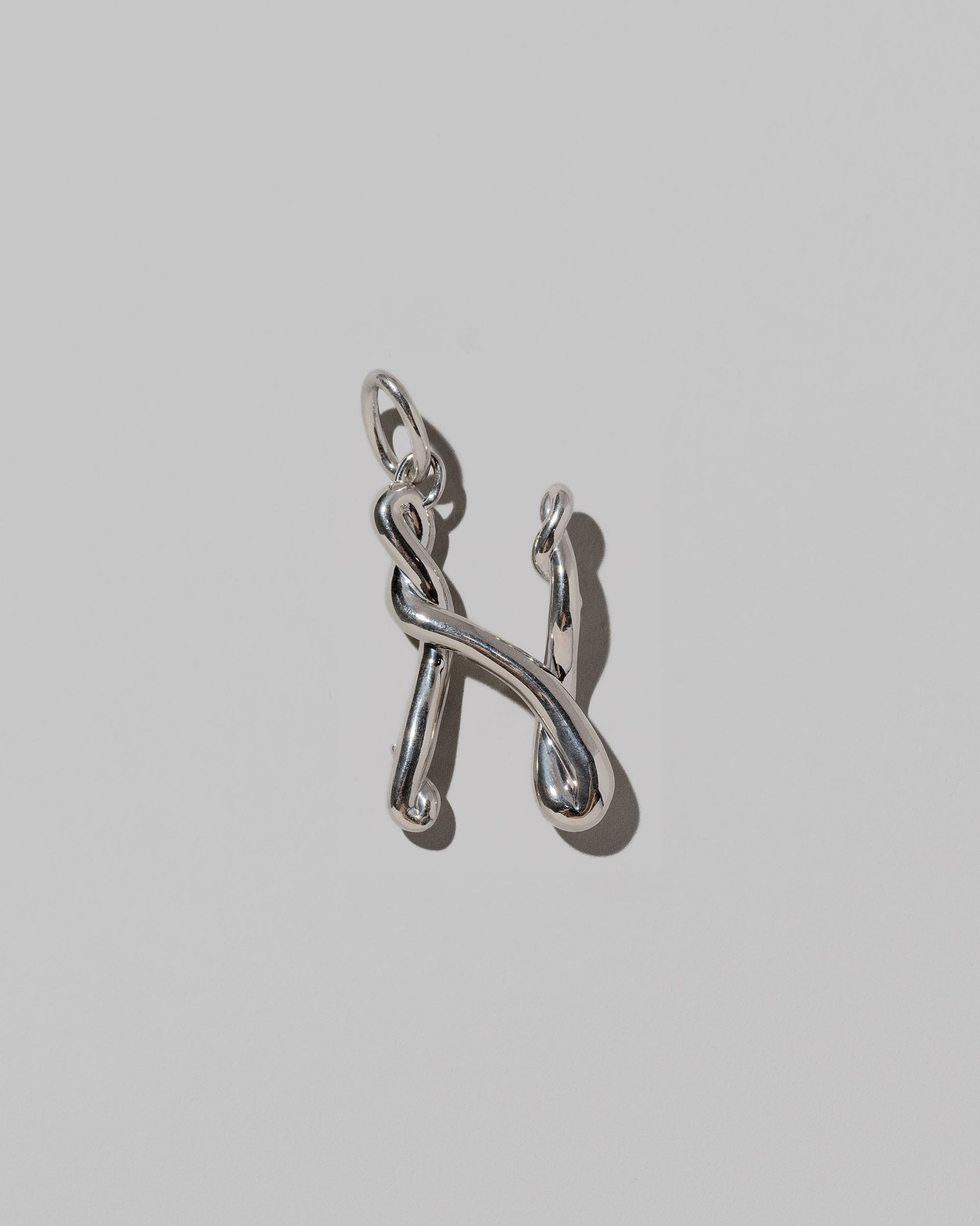 CRZM Sterling Silver Letter N Bag Charm on light color background.