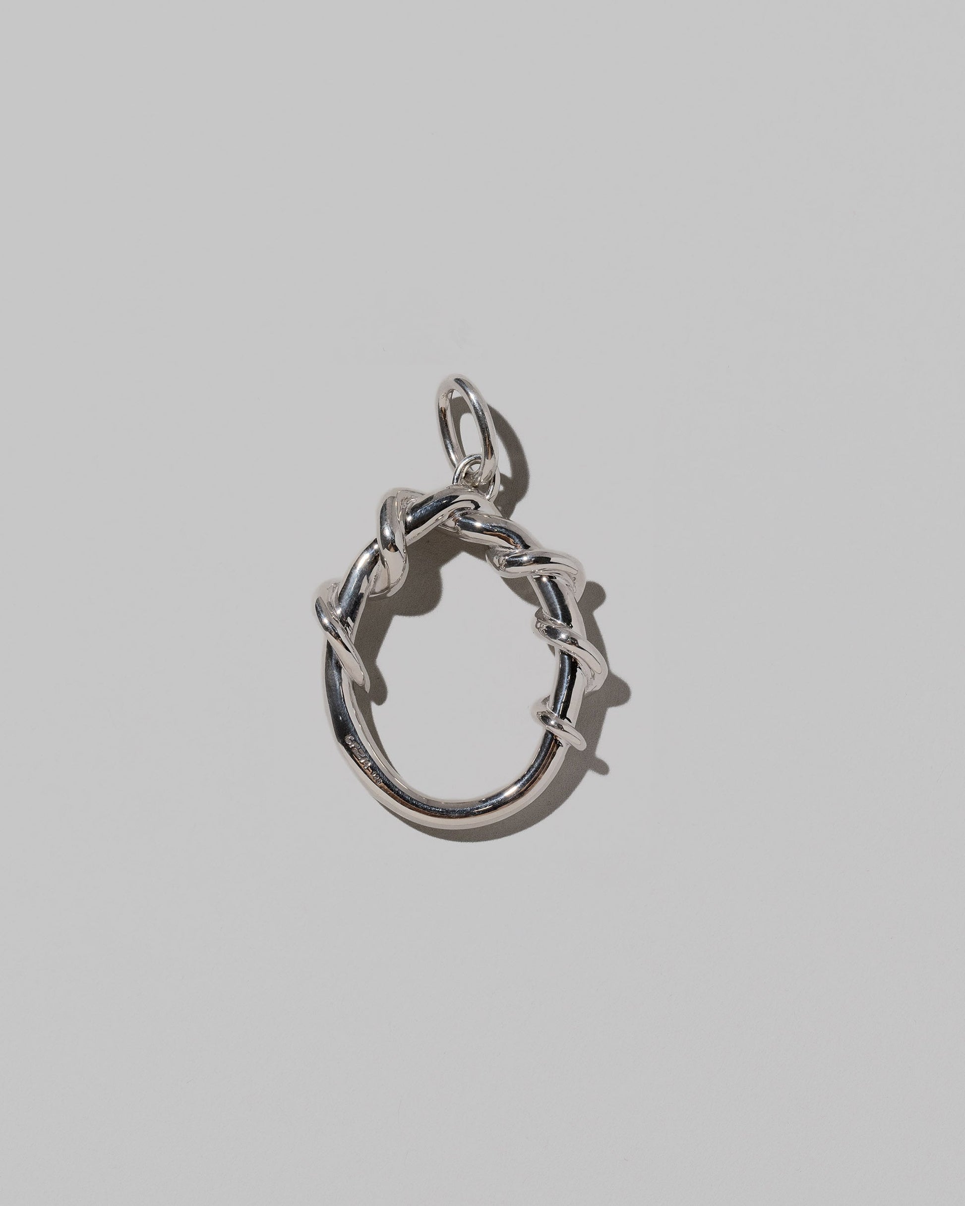 CRZM Sterling Silver Letter O Bag Charm on light color background.