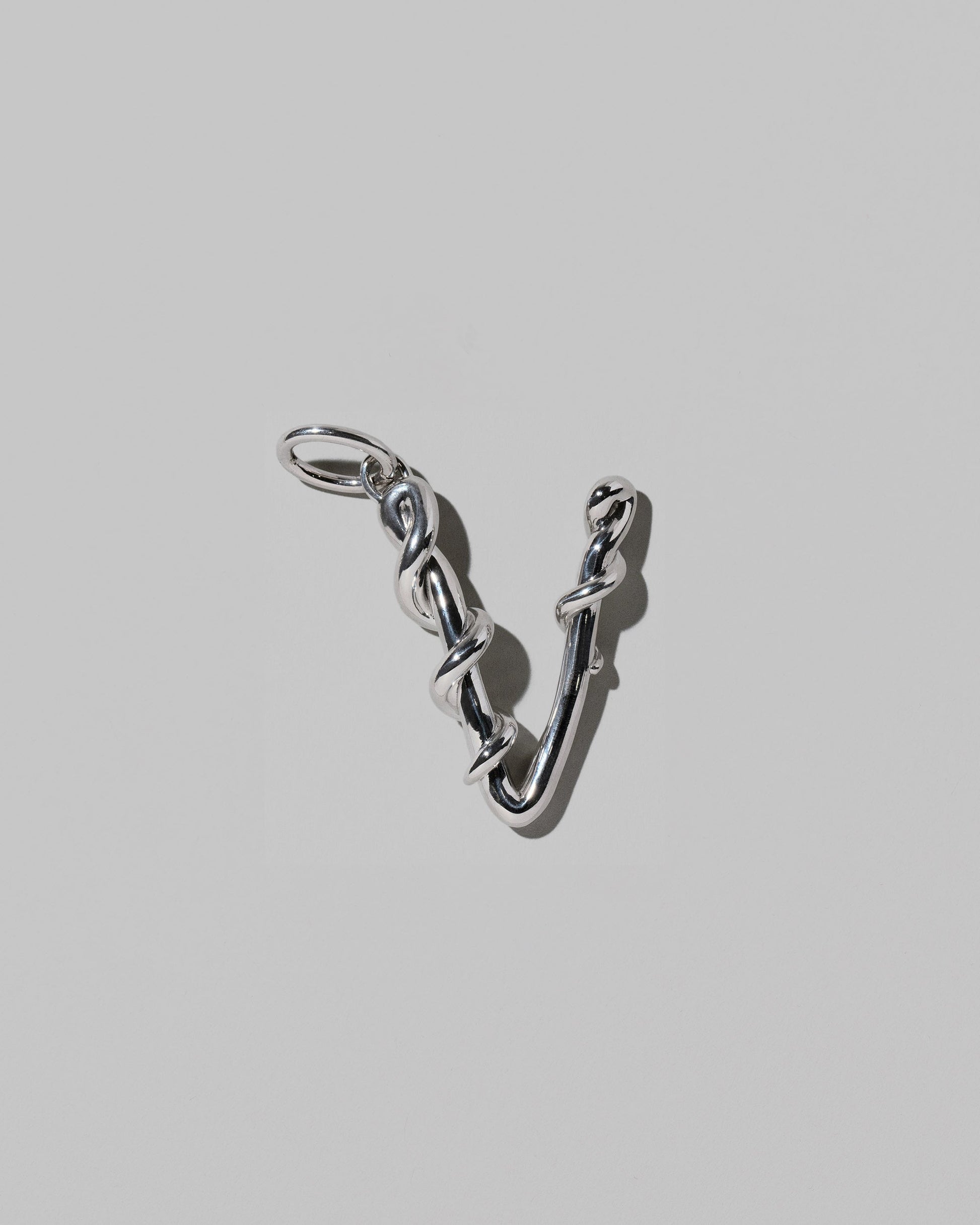 CRZM Sterling Silver Letter V Bag Charm on light color background.