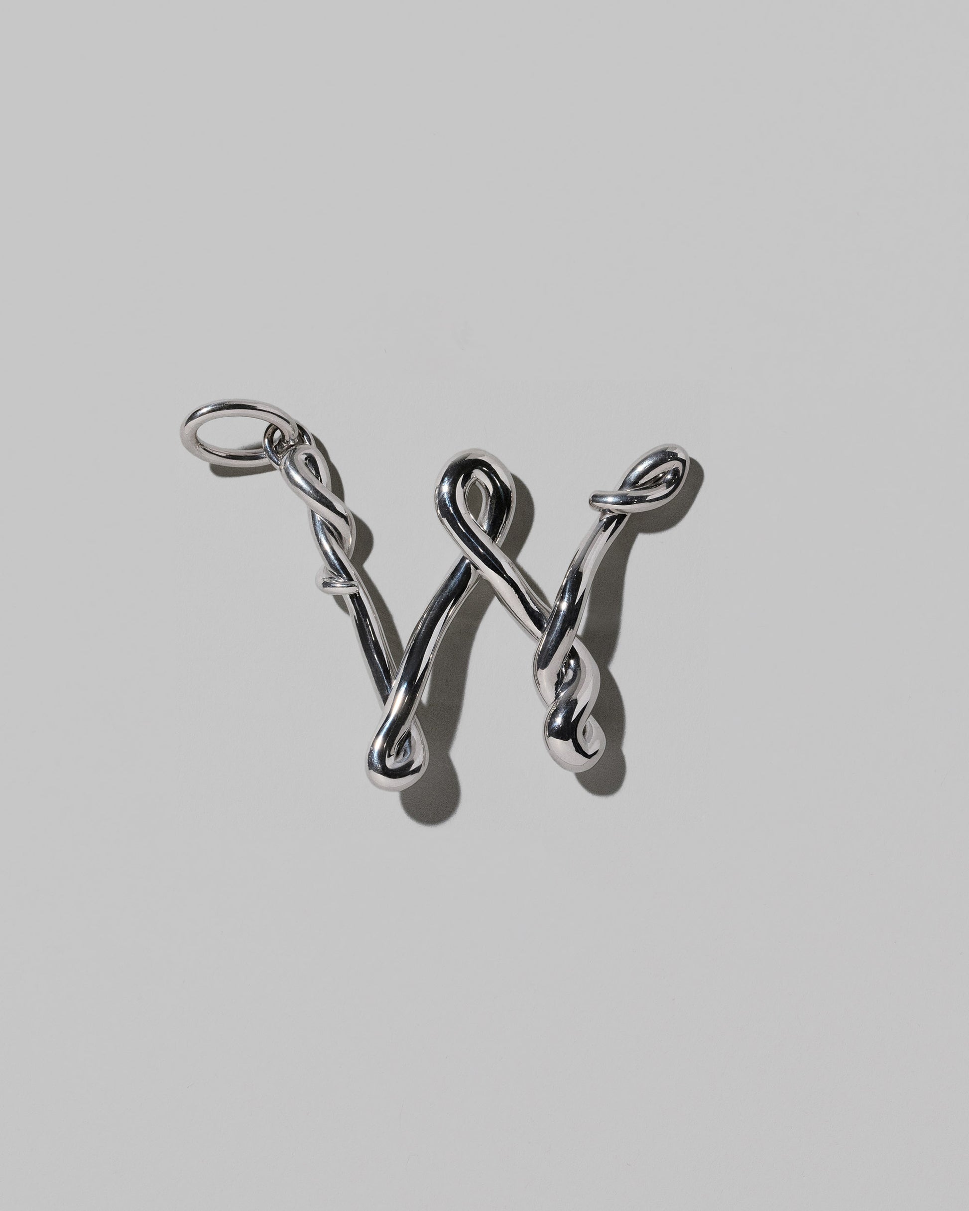 CRZM Sterling Silver Letter W Bag Charm on light color background.