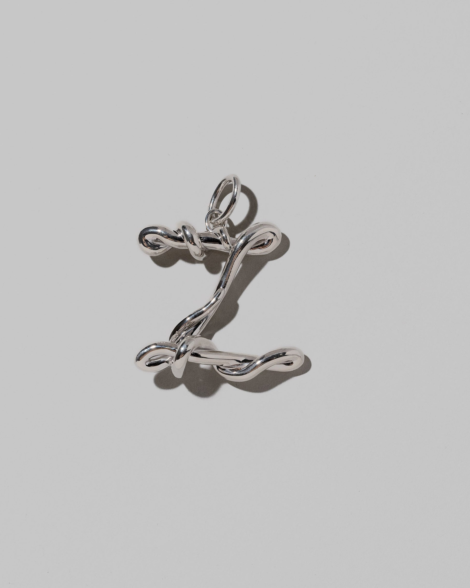 CRZM Sterling Silver Letter Z Bag Charm on light color background.