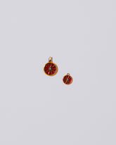 Group of Small and Large Sliced Fruit Charms - Tangerine on light color background.