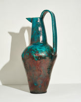 View from the back of the Emily Mullin Raku Pitcher I on light color background.