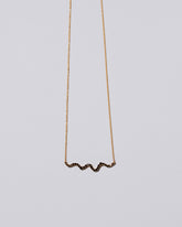 Closeup detail of the Black Diamond Ripple Wave Necklace on light color background.