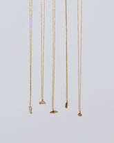 Group of Water, Eye, Foot, Lotus Blossom and Loop & Sphere Talisman Pendant Necklaces on light color background.