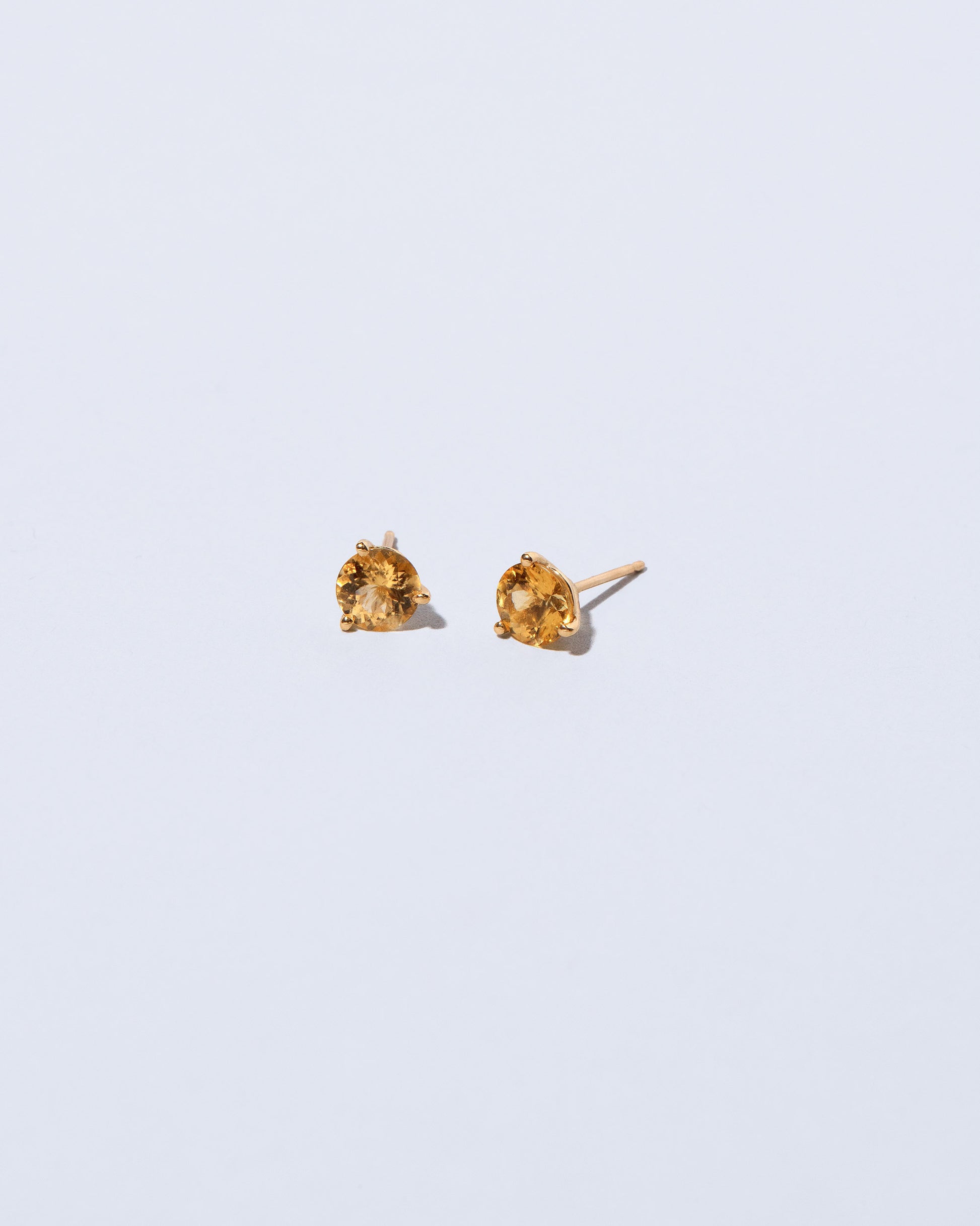 Super Yellow Beryl Martini Stud Earrings on light color background.