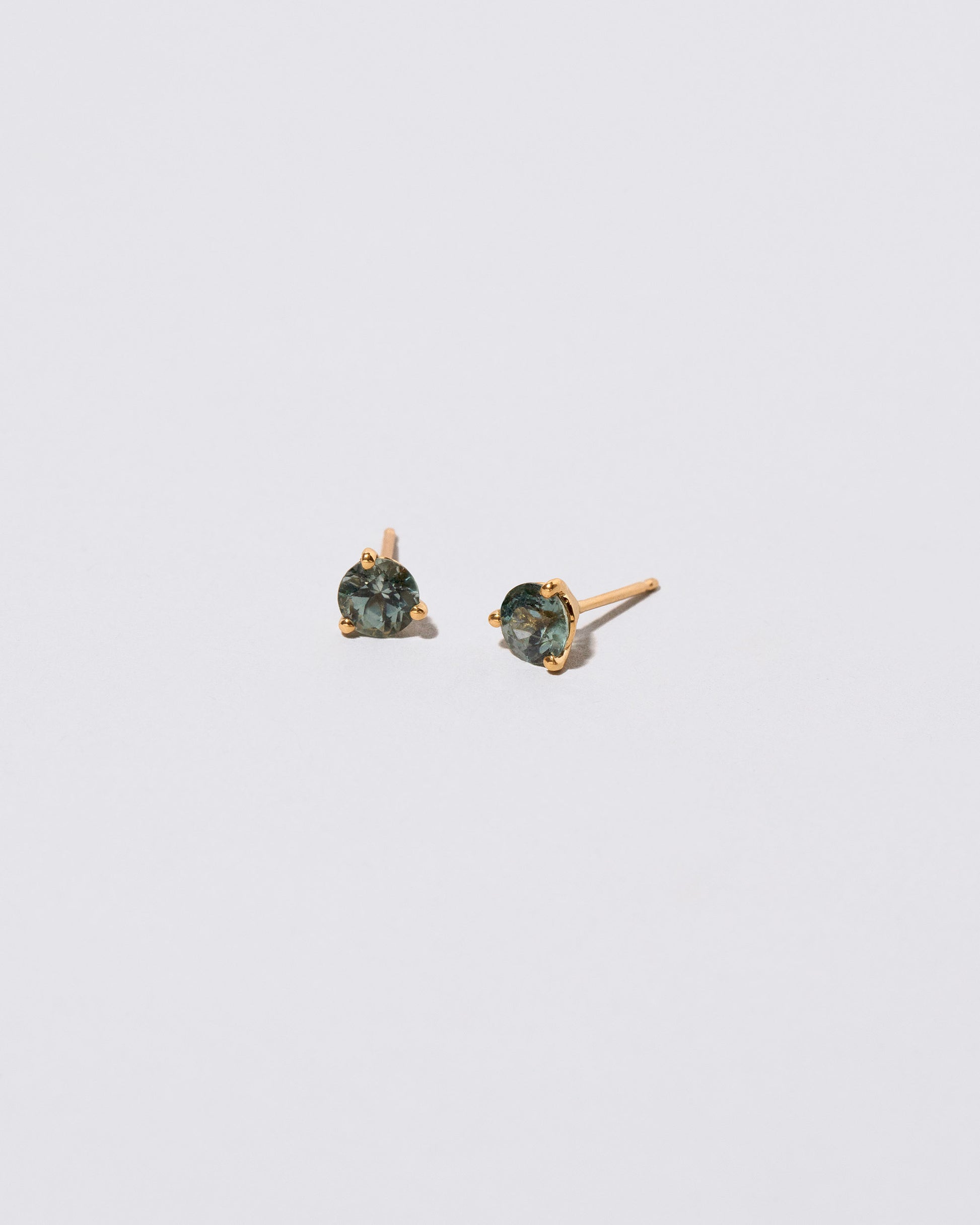 Mega Teal Sapphire Martini Stud Earrings on light color background.