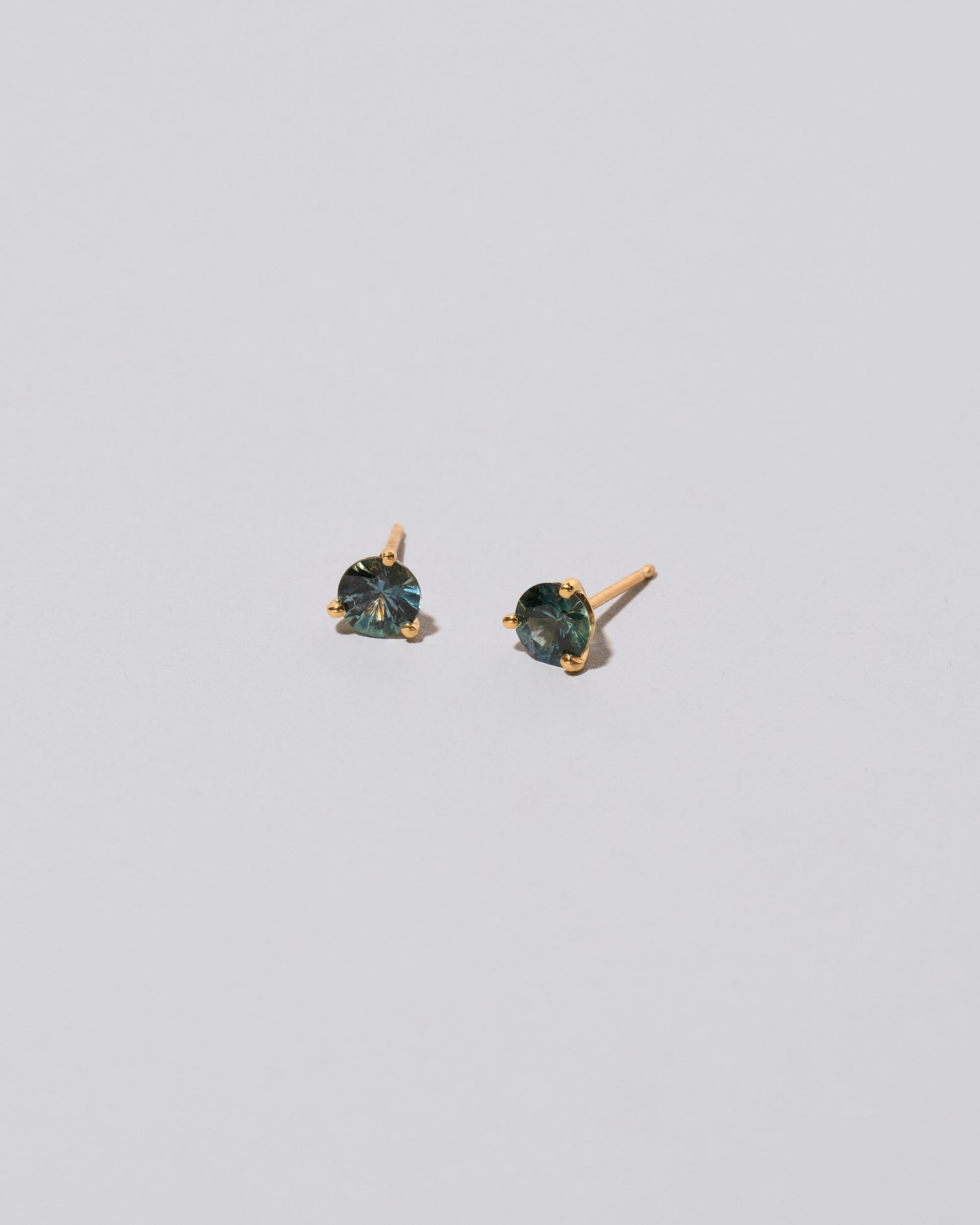 Mega Blue Sapphire Martini Stud Earrings on light color background.