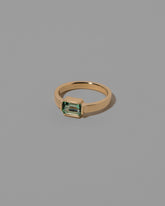 View from the side of the Emerald Fold Ring on light color background.