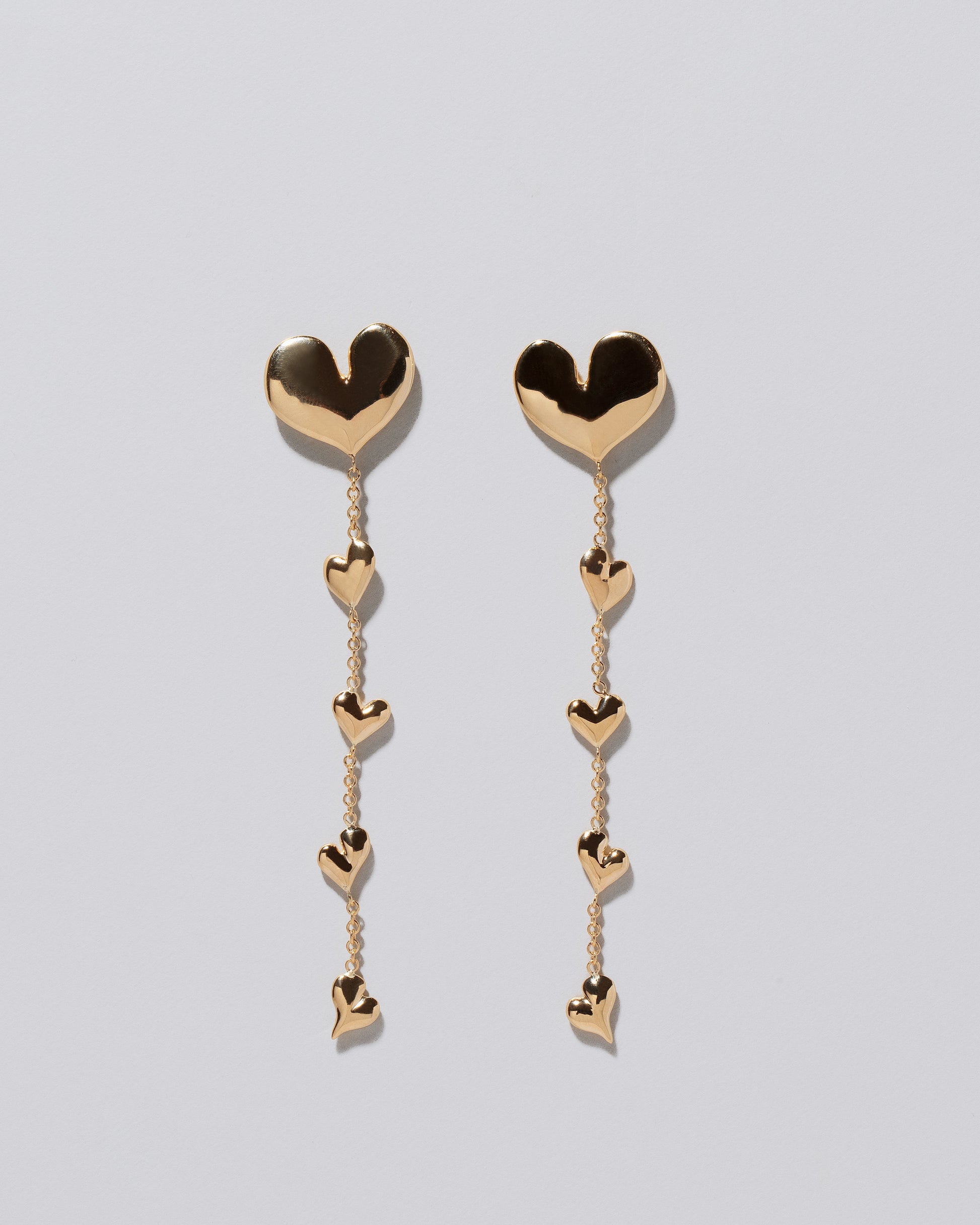 Gold Thousand & One Night Heart Shoulder Duster Earrings on light color background.