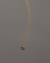 Peach Spinel Lover's Kiss Necklace on grey color background.