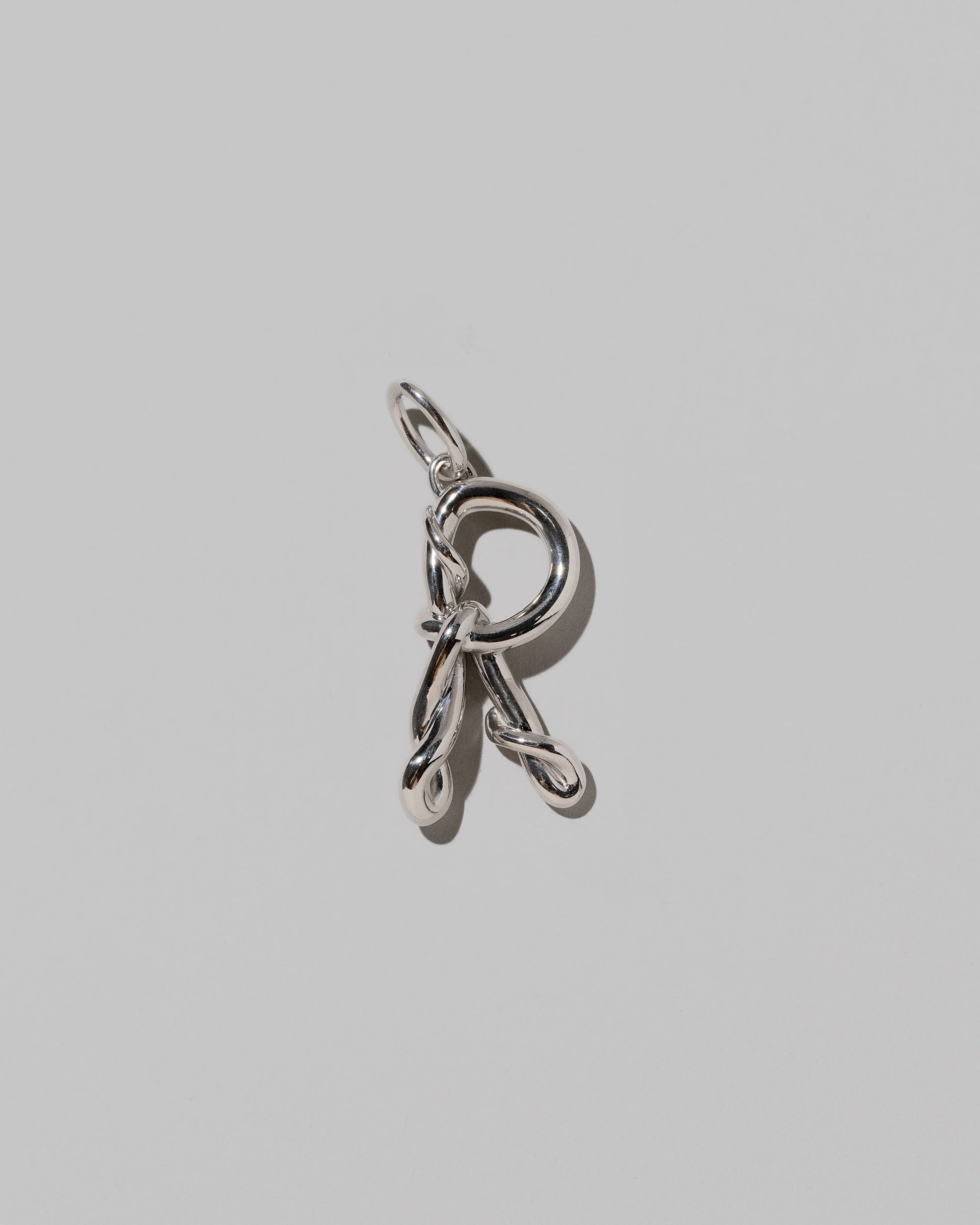 CRZM Large Letter R Charm set in sterling silver on light color background.