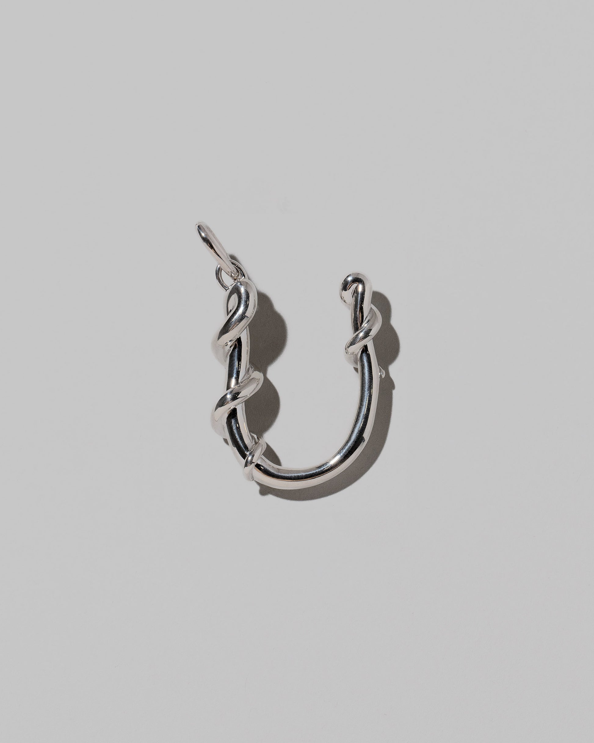 CRZM Large Letter U Charm set in sterling silver on light color background.