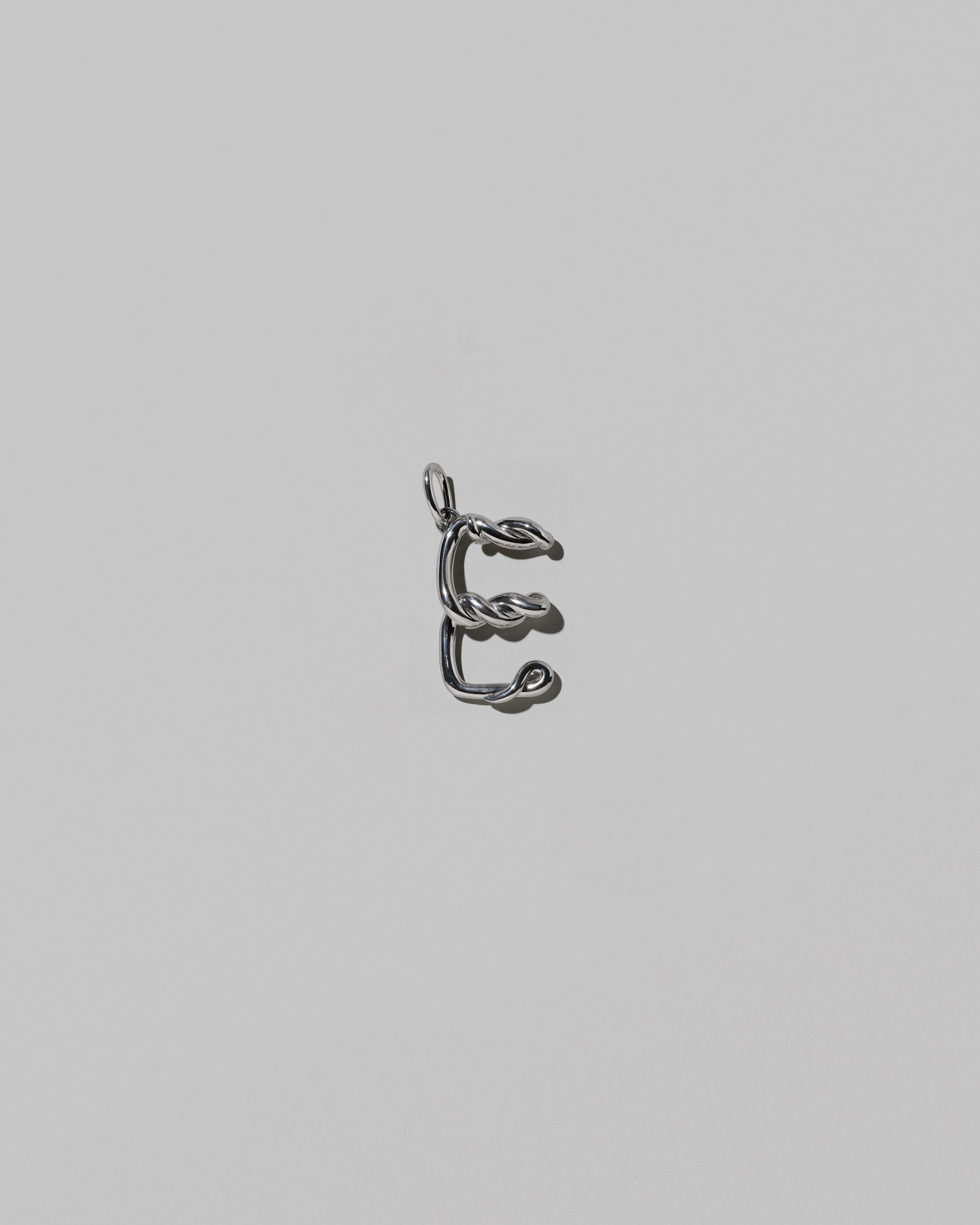 CRZM Medium Letter E Charm set in sterling silver on light color background.