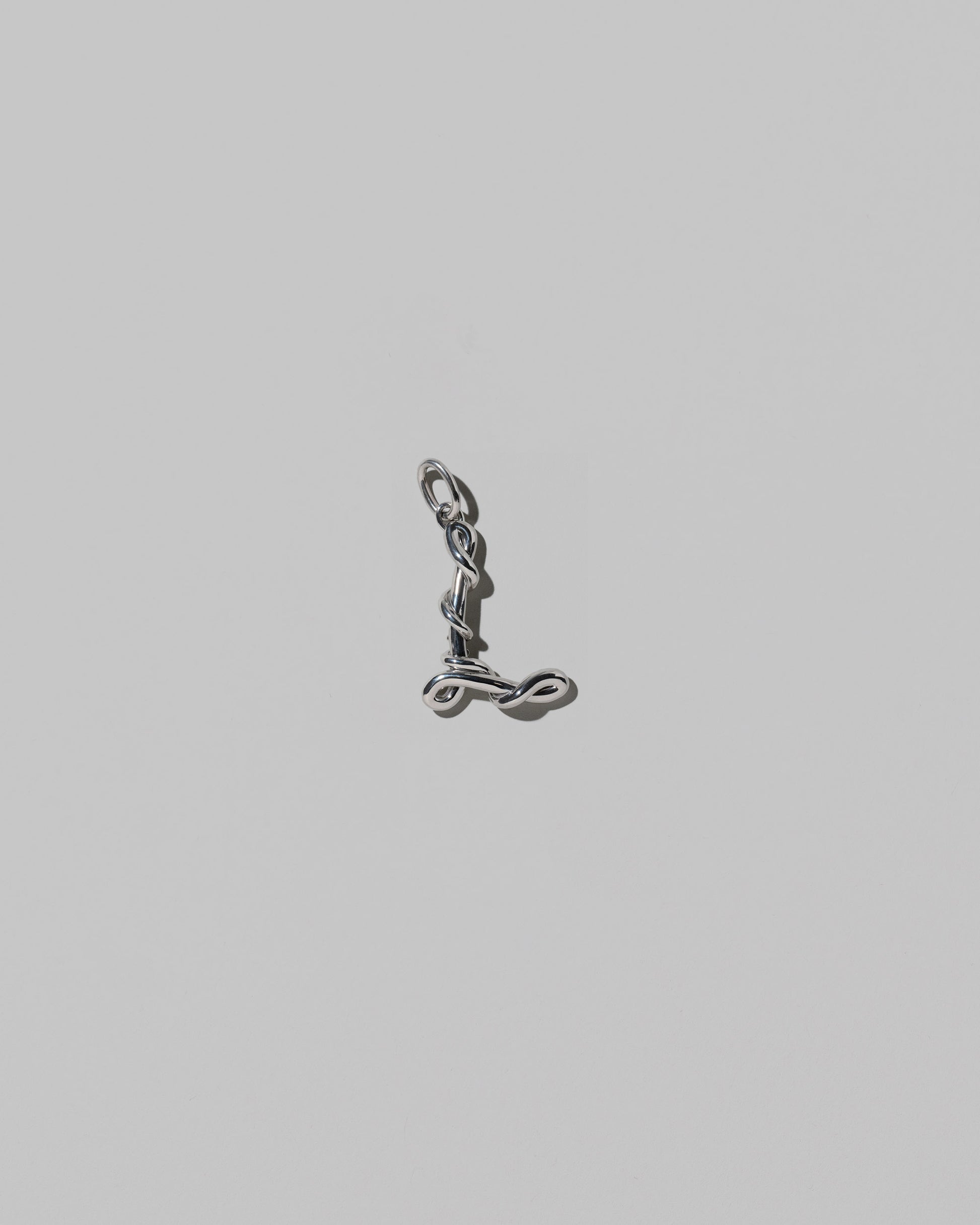 CRZM Medium Letter L Charm set in sterling silver on light color background.