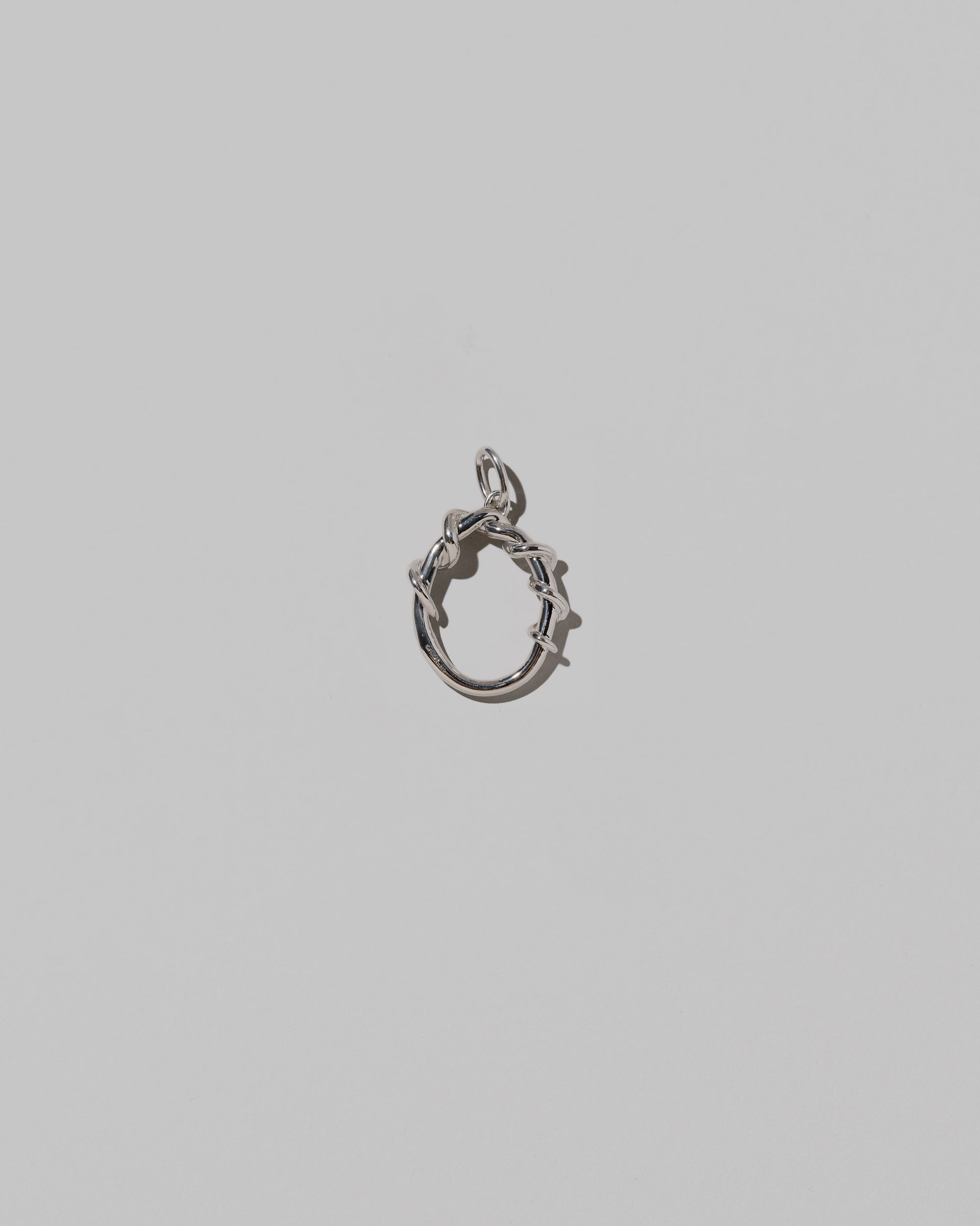 CRZM Medium Letter O Charm set in sterling silver on light color background.