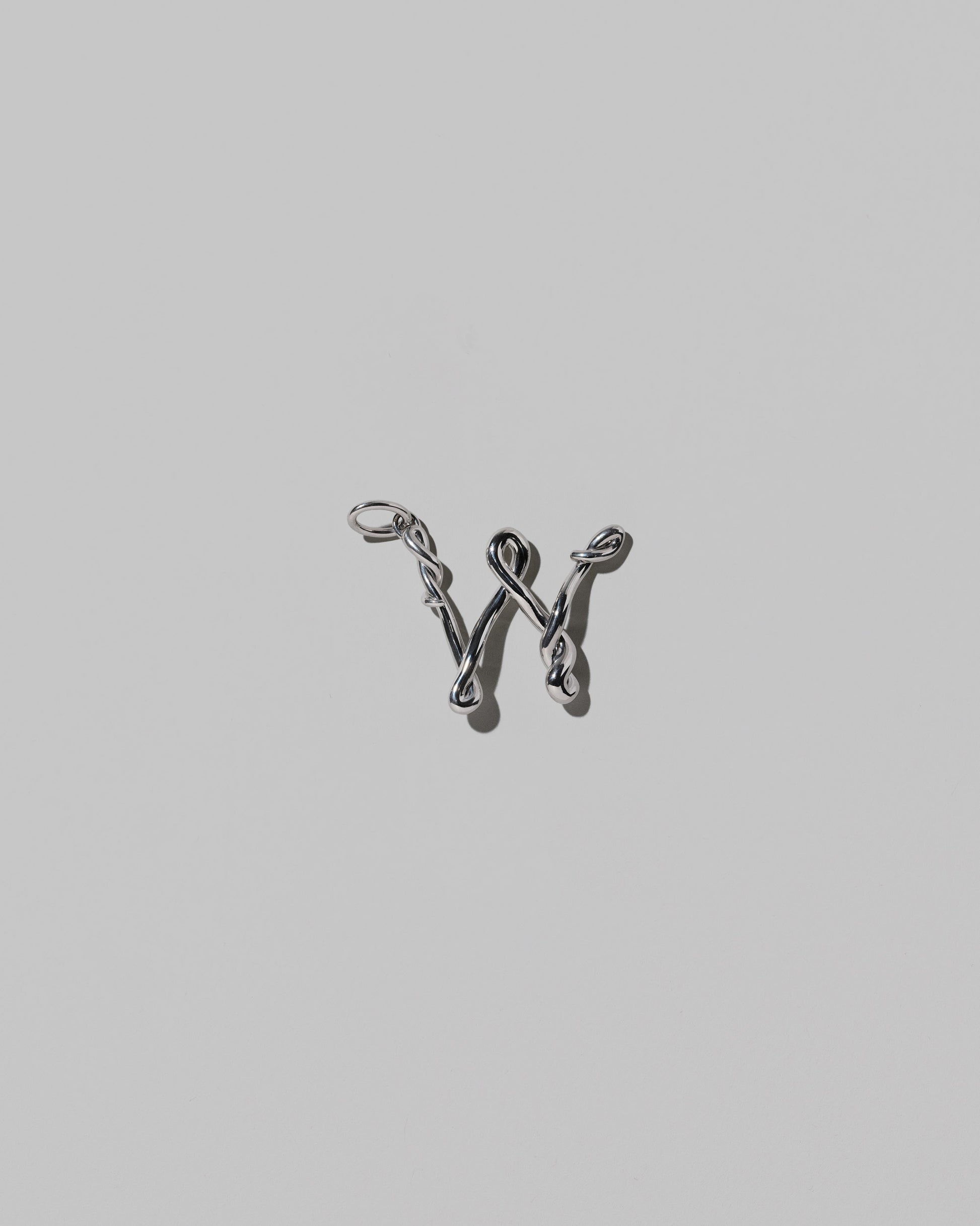 CRZM Medium Letter W Charm set in sterling silver on light color background.