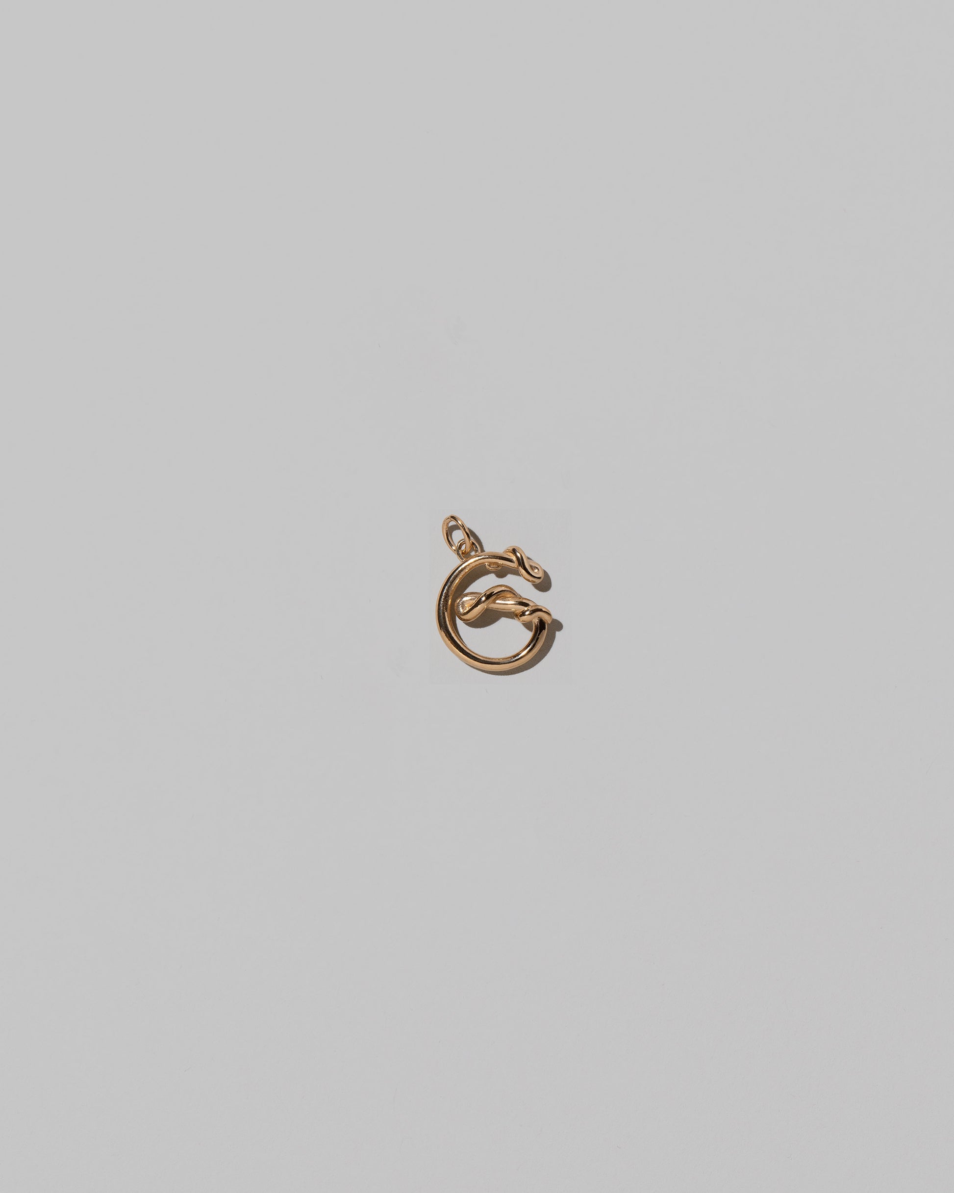 CRZM Mini Letter G set in solid gold on light color background.