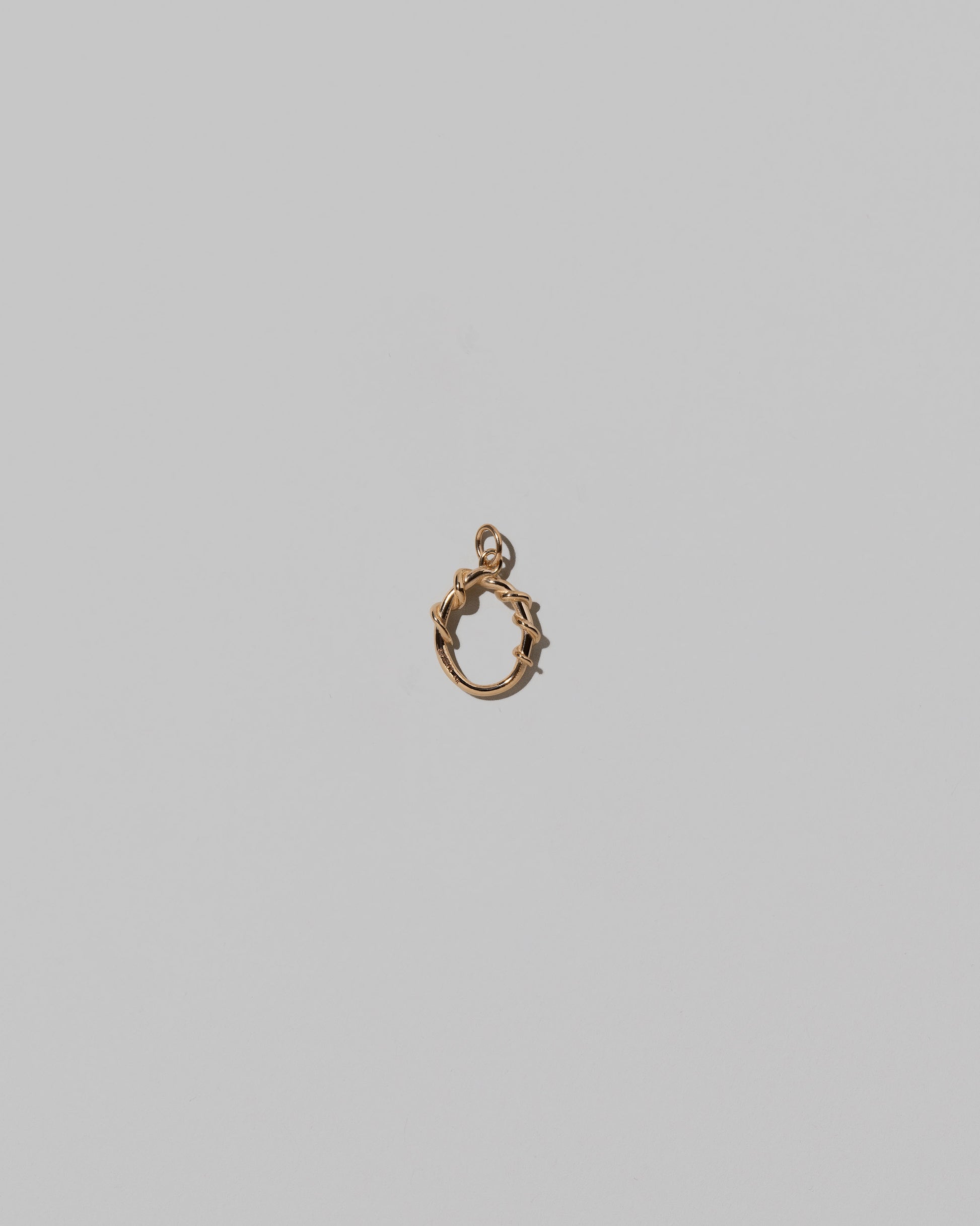 CRZM Mini Letter O set in solid gold on light color background.