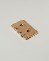 View from the back of the Pearce Objects Cast Bronze Mix Tape on light color background.